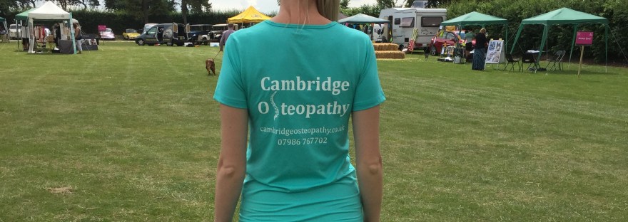 Image of a female wearing a "Cambridge Osteopathy" T-shirt showing the website and telephone number